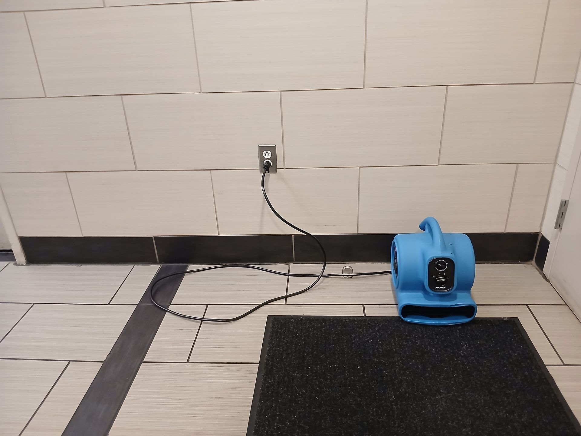 A portable air mover positioned on an indoor floor